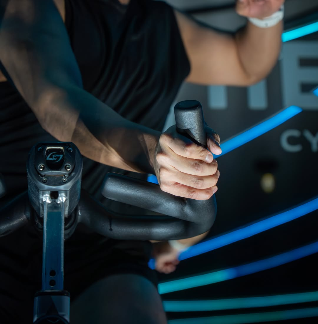 Manos sobre el manubrio en clase de cycling